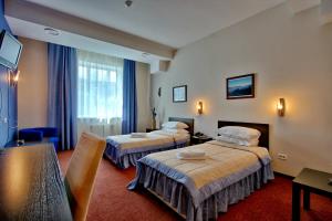 Habitación de hotel con 2 camas y mesa en Barcelona Spa-Hotel, en Ulyanovsk