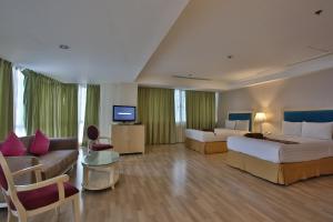 セブシティにあるCrown Regency Hotel & Towersのベッド2台とソファが備わるホテルルームです。
