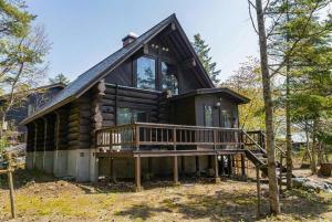 a log cabin with a porch and a deck at Reposer Hakuba Hotel and Offsite Villa in Hakuba
