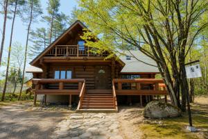 a log cabin in the woods with a tree at Reposer Hakuba Hotel and Offsite Villa in Hakuba