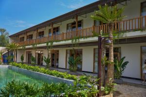 a building with a pool and a palm tree at Chài Homestay Sầm Sơn in Sầm Sơn