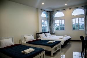 two beds in a room with two windows at Plern Pitch Residence in Pak Chong +100 photos