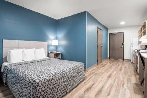 a bedroom with a bed and a blue wall at WoodSpring Suites Lancaster North in Lancaster +23 photos