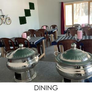 a dining room with tables and chairs and a pot at Snowpeak Retreat in Hundar +4 photos