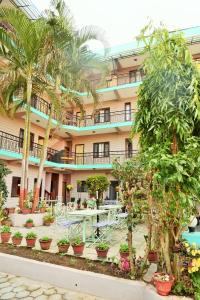 een hotel met palmbomen voor een gebouw bij Hotel Travel Inn in Pokhara