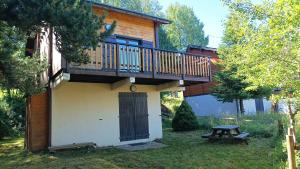 a cabin with a deck and a picnic table in the yard at Chaguimama Snow in Eyne