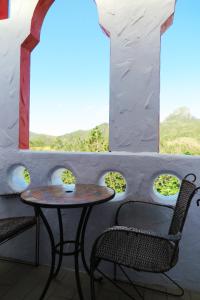 Una mesa y sillas en una habitación con ventanas. en Kenting Sin Sin Hotel II, en Kenting