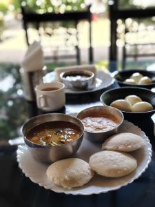 a table topped with bowls of soup and biscuits at Athirappilly Ambady Resort in Athirappilly
