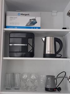 a microwave sitting on top of a shelf with glasses at Elegance Apartments Mesologgi in Missolonghi