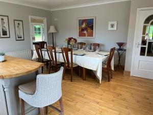 a dining room with a white table and chairs at White House tree view in Drumshanbo