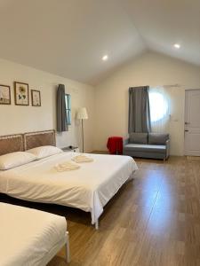 a bedroom with two beds and a couch in it at โรงแรมซุนเซนโฮมแอนด์คาเฟ่ in Ban Na Lao