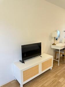 a living room with a flat screen tv on a white cabinet at โรงแรมซุนเซนโฮมแอนด์คาเฟ่ in Ban Na Lao