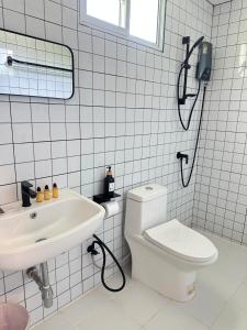 a white bathroom with a toilet and a sink at โรงแรมซุนเซนโฮมแอนด์คาเฟ่ in Ban Na Lao