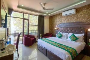 a bedroom with a large bed and a large window at Treebo Roshan House Near Mcleodganj in McLeod Ganj