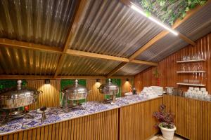 a restaurant with a counter with pots and pans at Treebo Roshan House Near Mcleodganj in McLeod Ganj