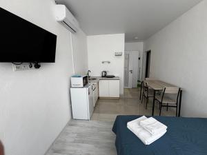 a room with a bed and a kitchen with a table at YARNA rooms by sea in Odesa