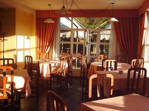 a dining room with tables and chairs and windows at Vega Del Sella in Arriondas
