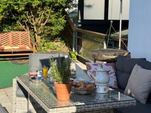 a table on a patio with a coffee table with plants at Ferienwohnung mit großem Balkon und Blick in den Taunus in Oberems +16 photos