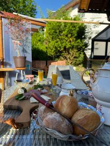 a table with loaves of bread and orange juice on it at Ferienwohnung mit großem Balkon und Blick in den Taunus in Oberems