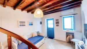 a bedroom with a bed and a blue door at In Alto in Plaka Milou