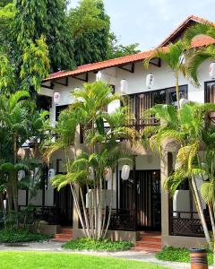 a building with palm trees in front of it at SUNSHINE BEACH Resort in Mui Ne