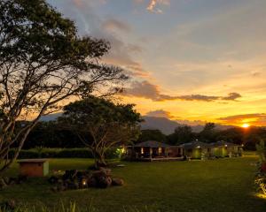 a sunset view of a house in a field at JAWS Retreat Bungalow in Haleiwa