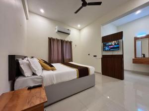 a bedroom with a bed and a flat screen tv at Thamira Grand palace in Agastīswaram +30 photos