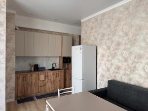 a kitchen with a white refrigerator and a table at Берег 2 in Bosteri