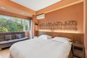 a bedroom with a bed and a couch at Golden101 Bed and Breakfast in Jiufen