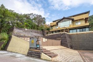 a house with a fence and a staircase in front of it at Golden101 Bed and Breakfast in Jiufen