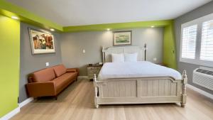 a bedroom with a bed and a couch and a chair at The SeaScape Inn in San Francisco