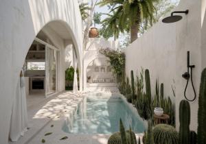 a swimming pool in the middle of a courtyard with cactus at Svara Boutique Residences in Uluwatu +10 photos