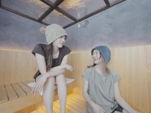 two girls are sitting in a sauna at Reposer Hakuba Hotel and Offsite Villa in Hakuba +23 photos