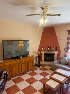 a living room with a flat screen tv and a couch at Traumhaus für 6 Personen mit spektakulärem privaten Pool und schönem Ausblick in die Natur in Hozanejos