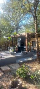 a house in the middle of a yard with trees at Unique Kruger Hide & Spa in Marloth Park