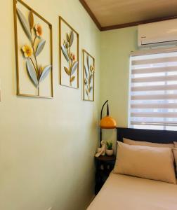 a bedroom with a bed and three pictures on the wall at Skys Transient House Unit 1 in Manolo Fortich