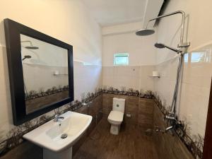 a bathroom with a sink and a toilet and a mirror at Maya 44 Boutique Ella in Ella +33 photos