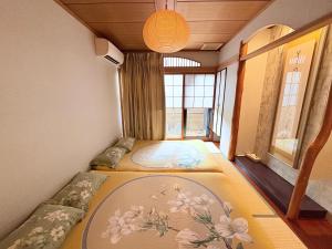 a room with three beds in it with a window at Just a short walk 心斎橋 Glico Sign 1min 道頓堀30-second 黒門市場 難波駅 Dotonbori Guesthouse 松の阁 in Osaka