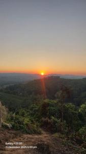 a sunset from the top of a hill with trees at Keyangjhiri Eco Resort, Lama, Bandarban in Bāndarban
