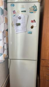 a white refrigerator with magnets and papers on it at Sunrise Panorama in Bokonbayevo
