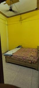 a bed in a room with a yellow wall at Hotel blue moon in Shāmli