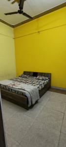 a bed in a room with a yellow wall at Hotel blue moon in Shāmli