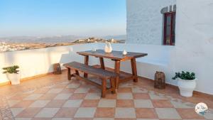 a wooden table and a bench on a balcony at In Alto in Plaka Milou