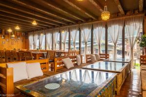 a restaurant with a glass table and wooden chairs at Phuntsho Guest House in Jakar