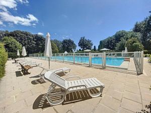 a pool with two lounge chairs and a umbrella at Chambre dans charmant Cottage dans résidence agréable in Grasse