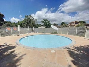 a pool with chairs and umbrellas in a yard at Chambre dans charmant Cottage dans résidence agréable in Grasse +16 photos
