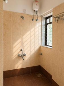 a shower in a bathroom with a window at Sk Holiday Apartment in Alibaug