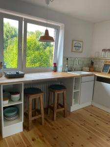 a kitchen with two stools and a counter with a window at Weener - City Apartment mit Garten in Weener