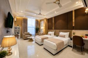 a hotel room with two beds and a desk at Hotel Aroma Suites Delhi - With Free Airport Drop in New Delhi +93 photos