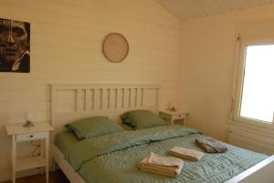 ein Schlafzimmer mit einem Bett, auf dem zwei Handtücher liegen in der Unterkunft Chalets Vacances in Avenches + 10 Fotos